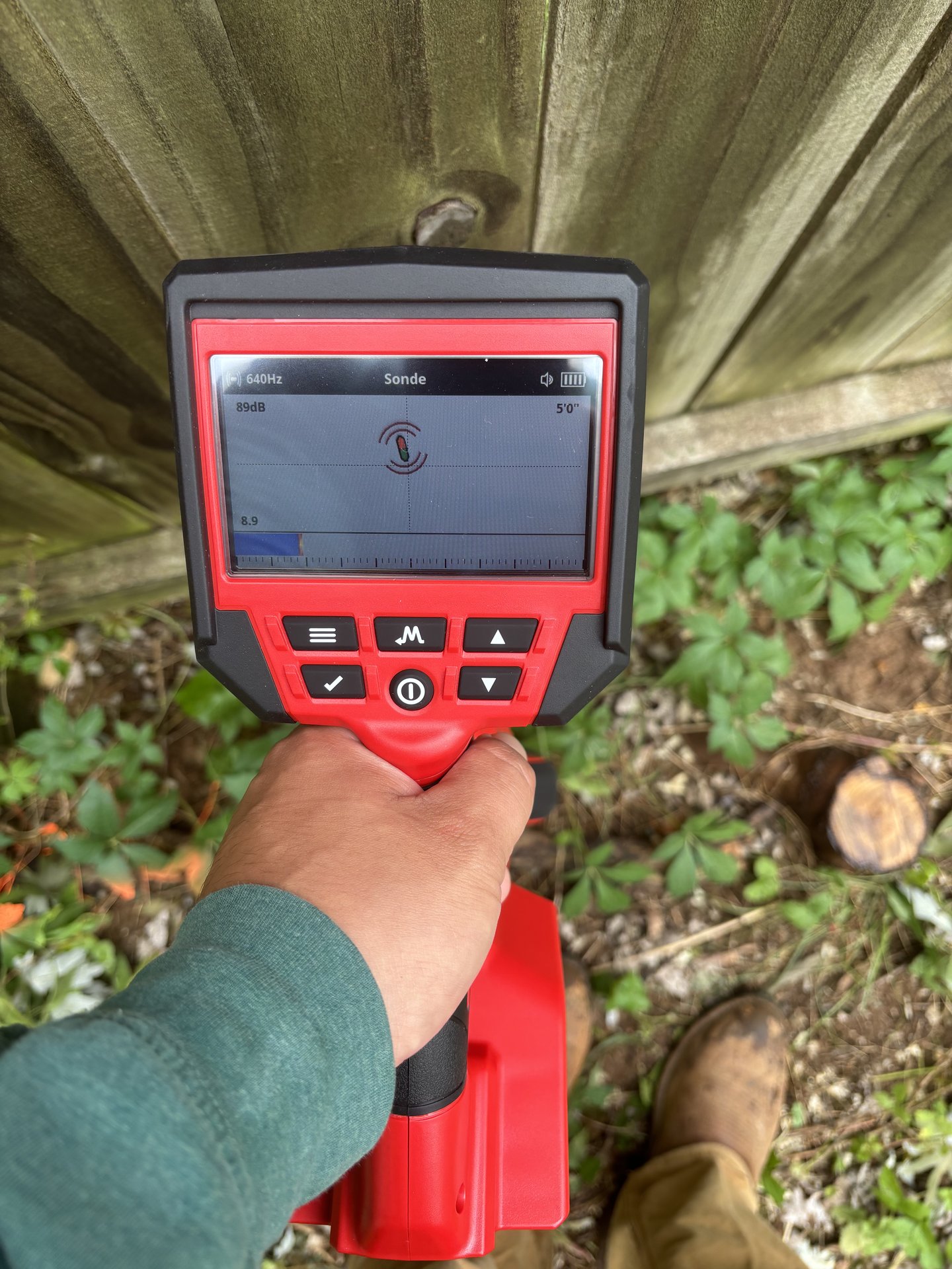 United Plumbing technician using electronic leak detection equipment to locate an underground utility line.